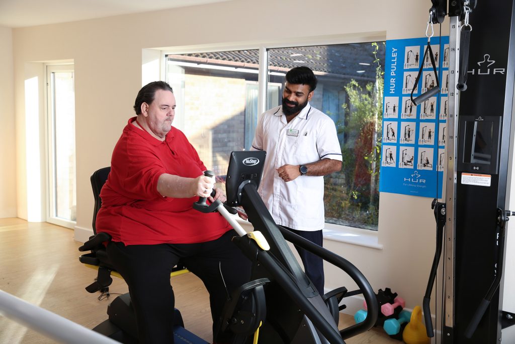 Image of a resident at Soham Lodge Care Centre using equipment at purpose made gym
